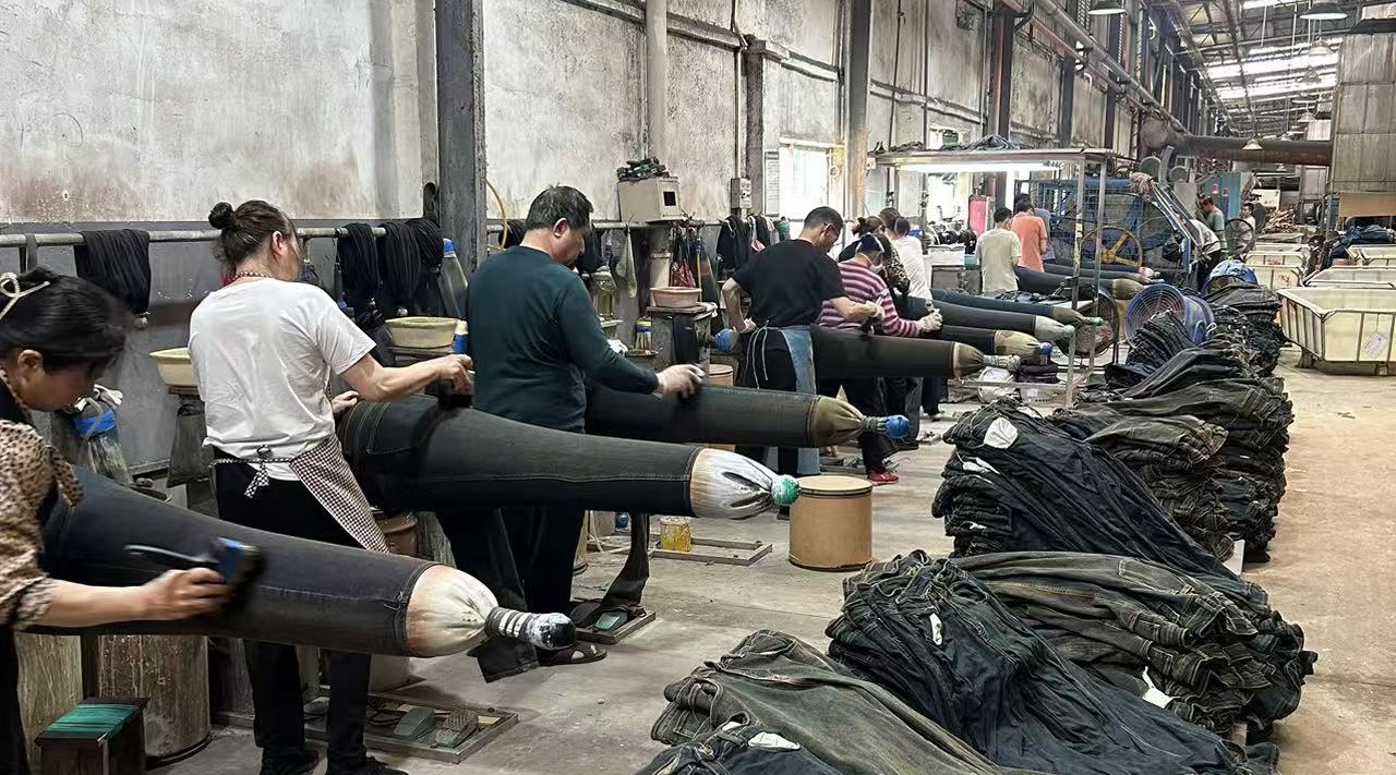 Artisans performing manual sanding and whiskering on inflatable mannequins to create authentic vintage character.